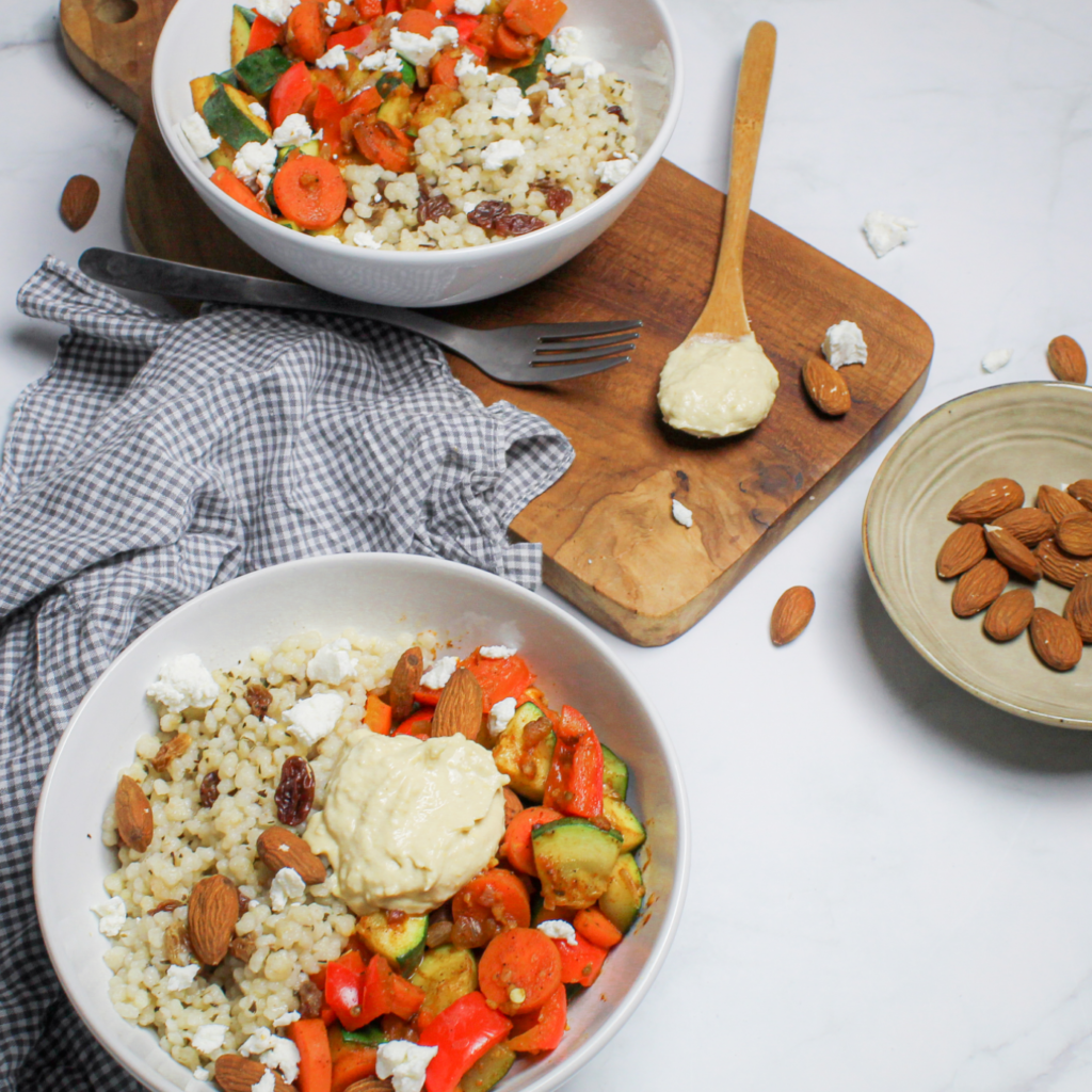 Glutenvrije couscous met ras el hanout groente, geitenkaas, hummus en amandelen